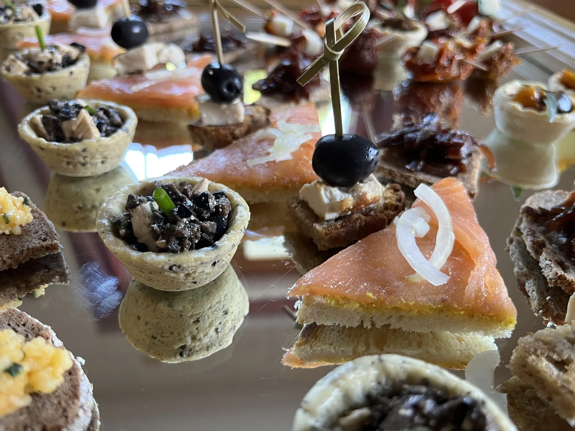 Elegante Apérohäppchen mit Räucherlachs, Oliven und herzhaften Tartelettes